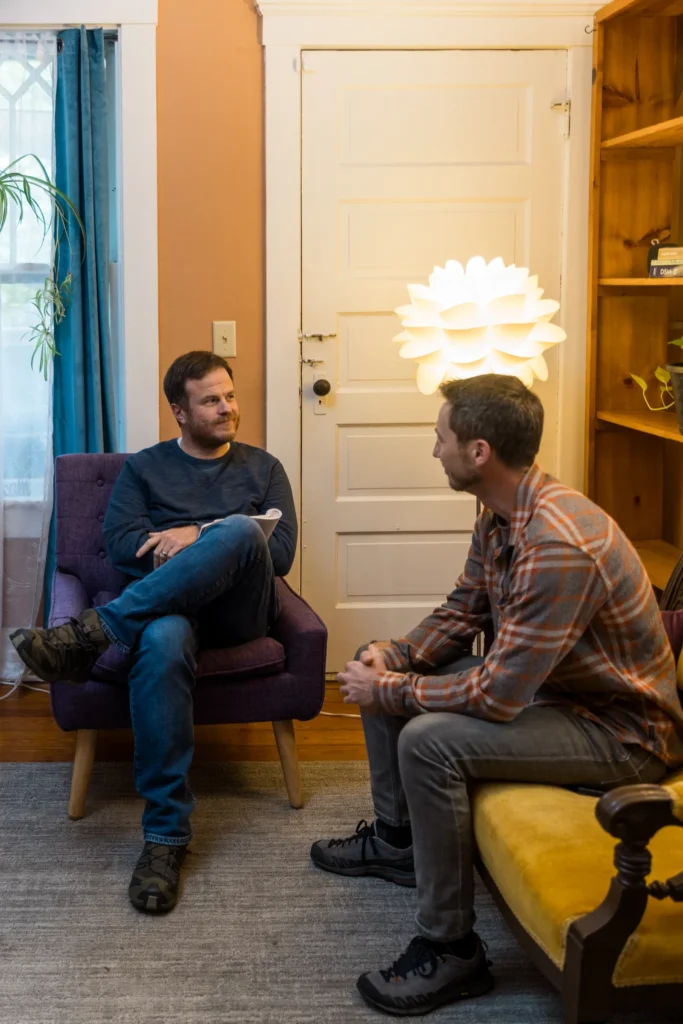 Two men sitting down looking at each other